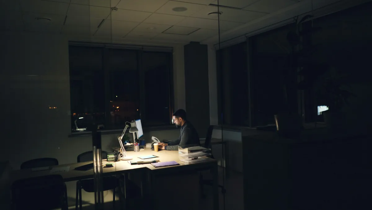One person working alone in a dark office at night
