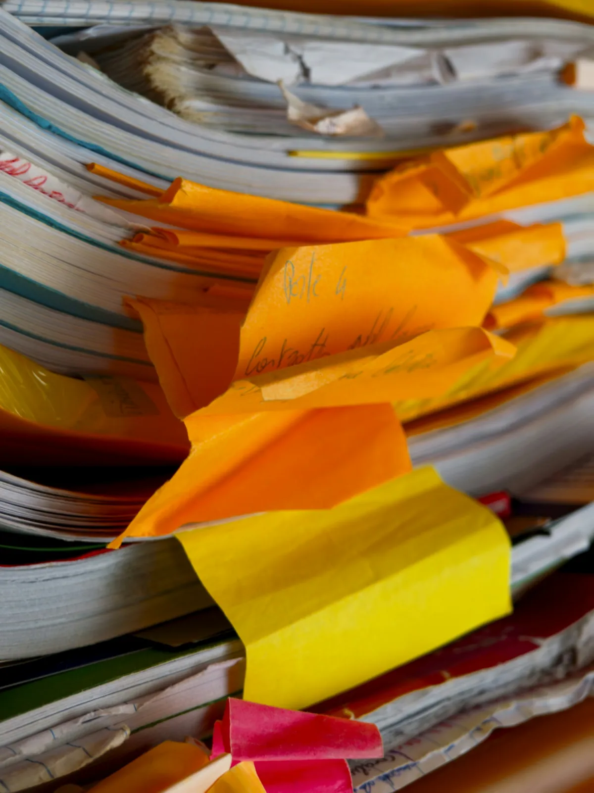 A stack of worn files and sticky notes